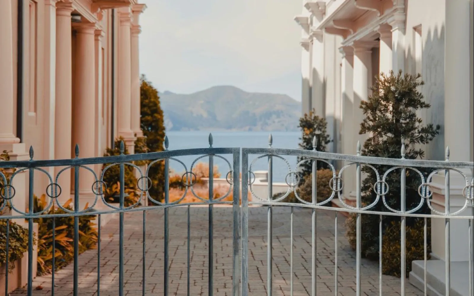 Grille en fer forgé entre deux villas ouvrant sur un lac, illustration des pièges qui jalonnent la gestion d’une fortune