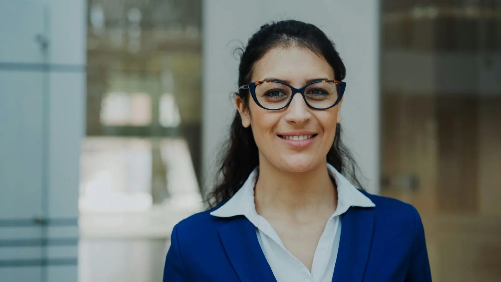 Claire, dirigeante de PME, devant les locaux de son entreprise